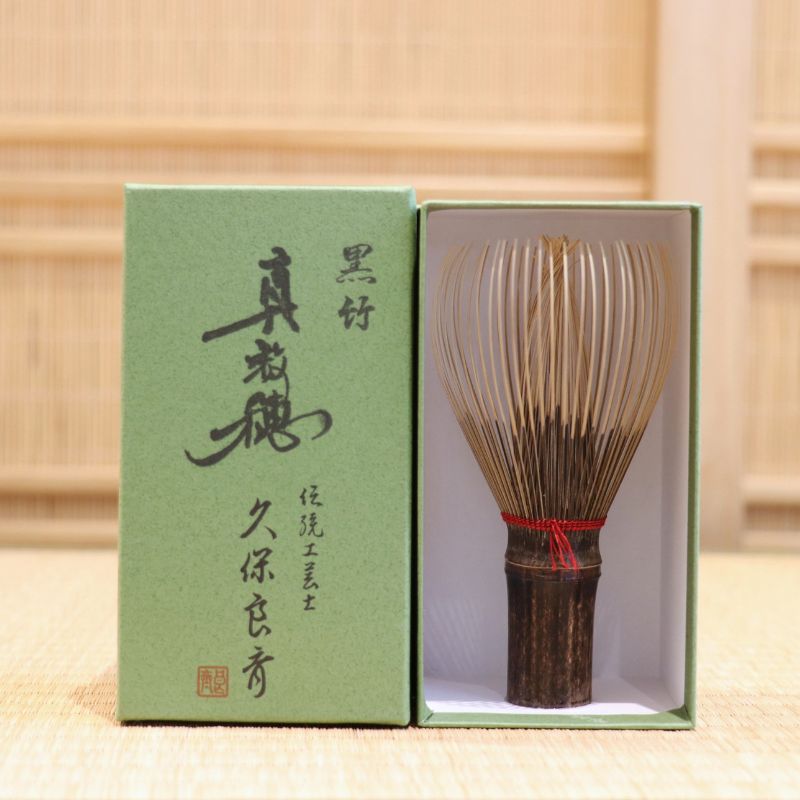 Ryosai Kubo handcrafted Takayama chasen made from Japanese black bamboo with Dark Red #4 thread, displayed beside its presentation box