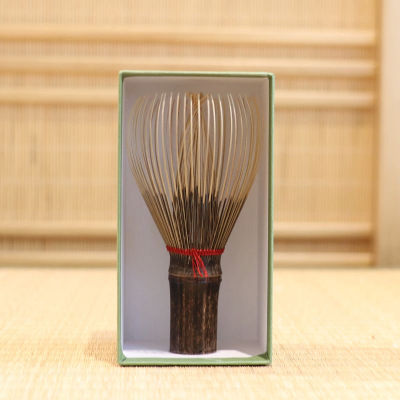 Ryosai Kubo black bamboo Takayama chasen with Dark Red #4 thread displayed upright inside its green presentation box