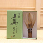 Ryosai Kubo handcrafted Takayama chasen made from Japanese black bamboo with Grey #37 thread, displayed beside its presentation box
