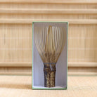 Ryosai Kubo black bamboo Takayama chasen with Grey #37 thread displayed upright inside its green presentation box