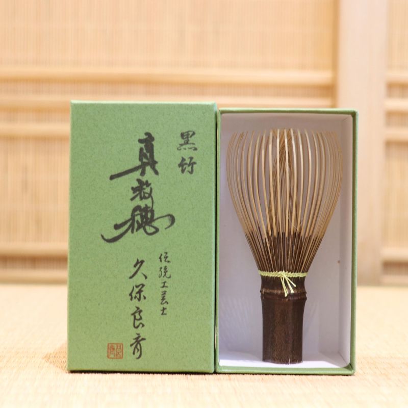 Ryosai Kubo handcrafted Takayama chasen made from Japanese black bamboo with Lemon #17 thread, displayed beside its presentation box