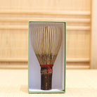 Ryosai Kubo black bamboo Takayama chasen with Maroon #5 thread displayed upright inside its green presentation box