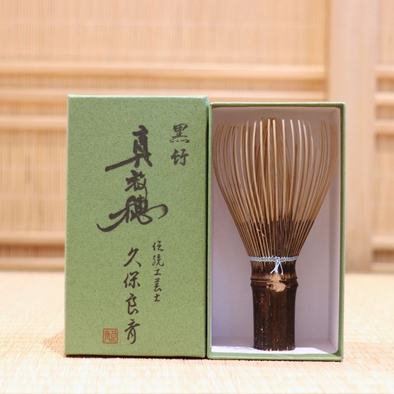 Ryosai Kubo handcrafted Takayama chasen made from Japanese black bamboo with Pale Blue #27 thread, displayed beside its presentation box