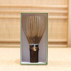 Ryosai Kubo black bamboo Takayama chasen with Pale Blue #27 thread displayed upright inside its green presentation box