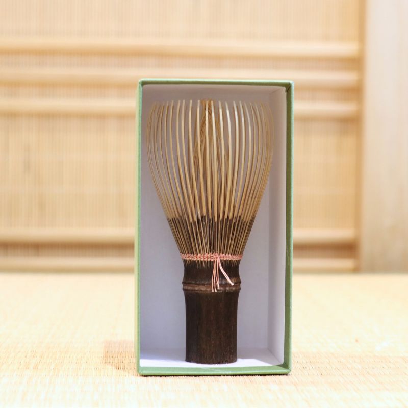 Ryosai Kubo black bamboo Takayama chasen with Coral #3 thread displayed upright inside its green presentation box