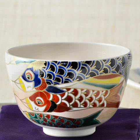 Close front view of the Saiei matcha bowl showing overlapping cobalt blue, red, and turquoise koinobori with detailed scales and gold accents.