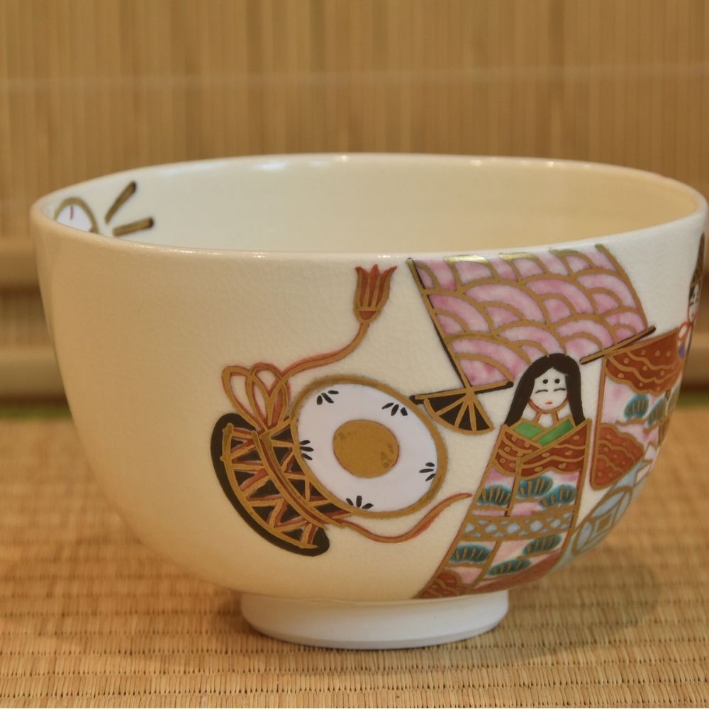 Left-side view of the Hina Matsuri matcha bowl showing an imperial doll, a circular drum, and detailed red and gold decoration.
