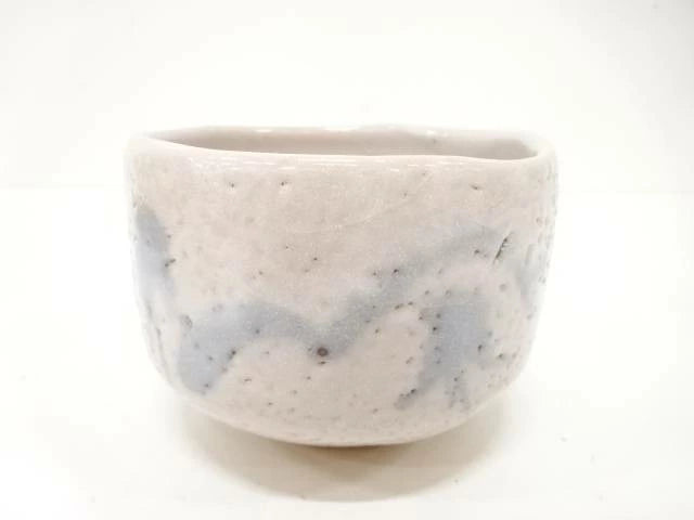 Front view of the Shigezo Sato Benishino chawan showing its milky ivory glaze, softly irregular rim, and misty blue-gray brushwork.