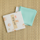 Mint green silk fukusa by Kitamura Tokusai with gift box on tatami for Japanese tea ceremony.