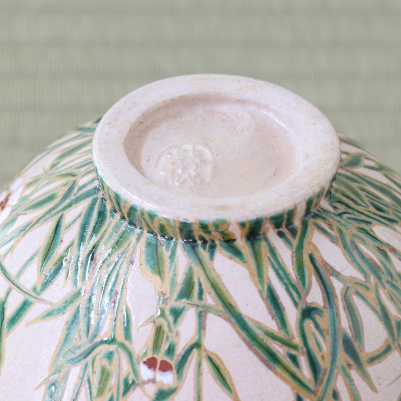 Bottom view of the Shisen Asano Nadeshiko matcha bowl showing its circular foot and floral decoration continuing across the pale pink exterior