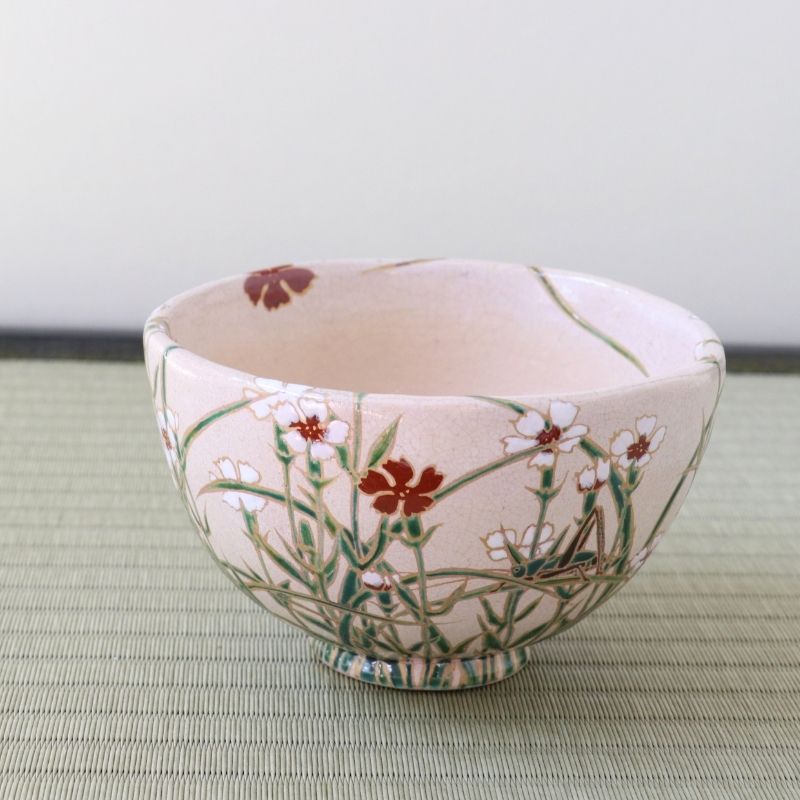 Side view of the Shisen Asano Nadeshiko chawan showing Japanese pink flowers and slender green grasses wrapping around the pale pink bowl
