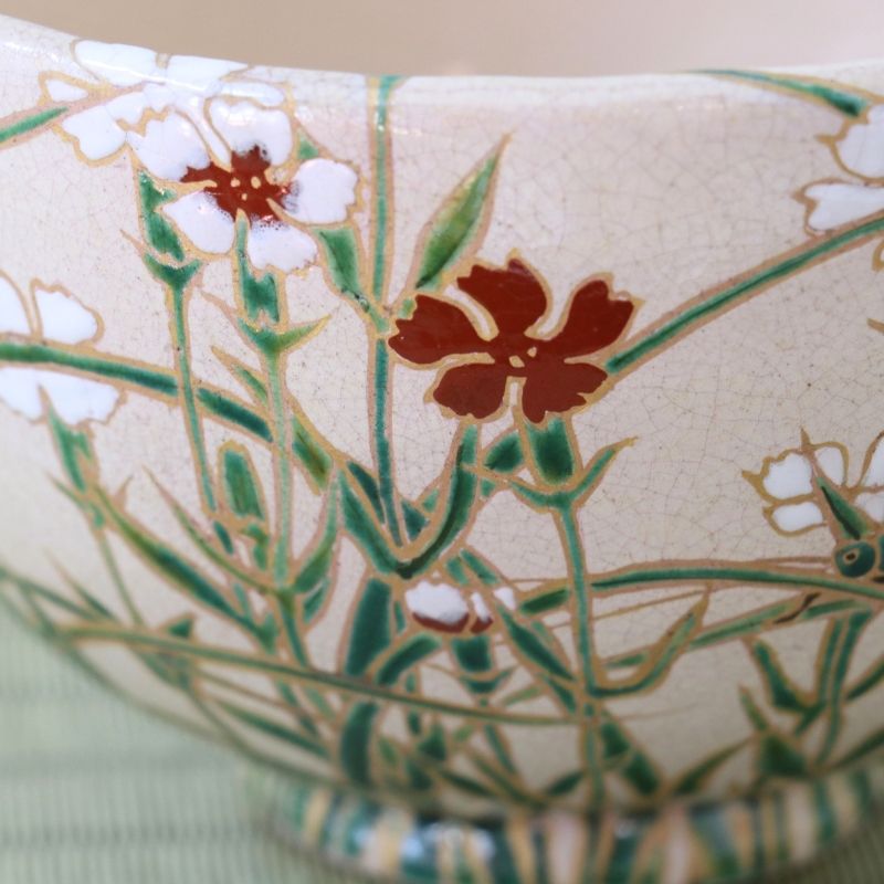 Close-up of the Nadeshiko decoration on the Shisen Asano matcha bowl showing white and deep red flowers among fine green stems and grasses