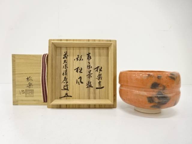 Pre-owned Shoraku Sasaki Red Raku matcha bowl titled Matsukaze displayed beside its open inscribed wooden storage box.