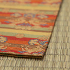 Angled detail of the folded kobukusa showing its woven border, silk texture, and layered floral-and-bird pattern.