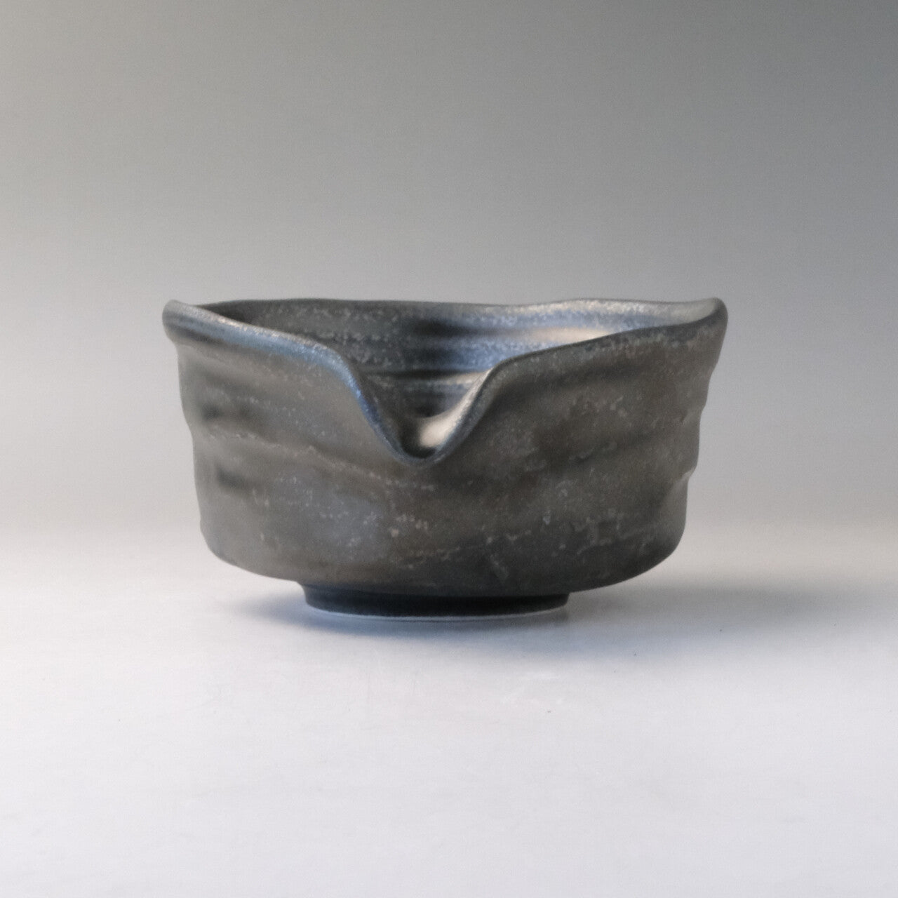 Front view of the Mino Ware katakuchi matcha bowl with its V-shaped pouring spout centered above the textured exterior.