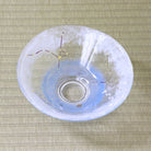 Top view of a handcrafted pale blue glass hirachawan decorated with shimmering stars and colored summer constellation lines on tatami.