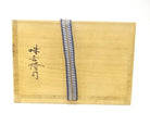 Exterior of the original wooden storage box with Japanese calligraphy, seals, and a blue woven securing cord for the Zuiun chawan.