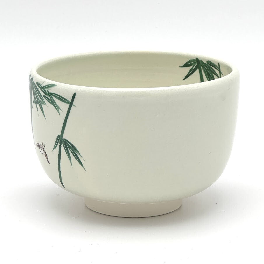 Angled view of the Take Suzume Kyo Ware chawan highlighting the hand-painted bamboo motif and ivory glazed form