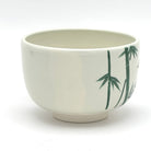 Side view of the Kyo Ware chawan showing hand-painted green bamboo against the warm ivory ceramic surface