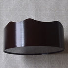 Black wall-mounted light fixture on a textured gray wall