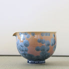 Tōan katakuchi matcha latte pouring bowl featuring an Ash Blue Hana-Kesshō flower crystal glaze with blue-gray crystalline patterns over a warm peach-toned surface