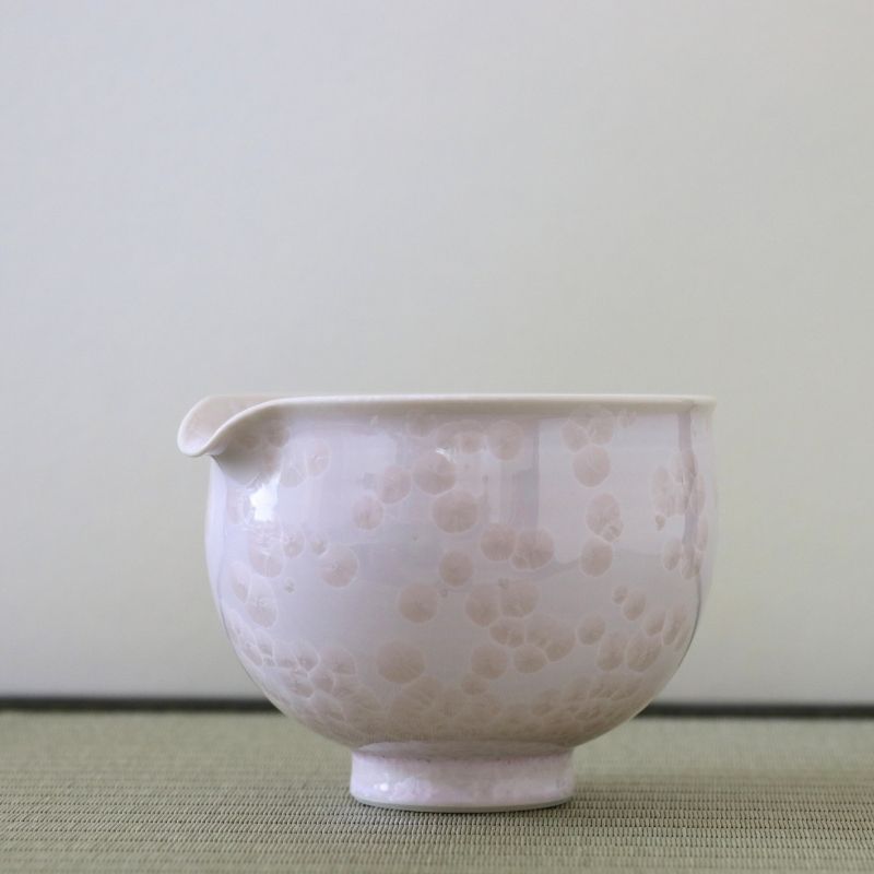 Side view of the Tōan Hana-Kesshō cherry blossom pink katakuchi bowl showing its rounded form, pouring spout, and pale flower crystal glaze patterns