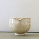 Spout view of the Tōan golden flower katakuchi matcha latte bowl highlighting the pouring lip and warm gold and cream flower crystal glaze patterns