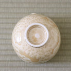 Underside view of the Tōan Hana-Kesshō golden flower katakuchi bowl showing its circular ceramic foot and crystalline glaze across the base