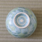 Underside view of the Tōan Hana-Kesshō green katakuchi bowl showing its circular ceramic foot and flower crystal glaze across the base