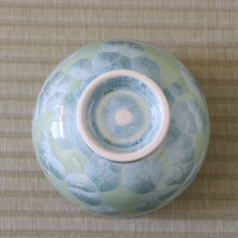 Underside view of the Tōan Hana-Kesshō green katakuchi bowl showing its circular ceramic foot and flower crystal glaze across the base
