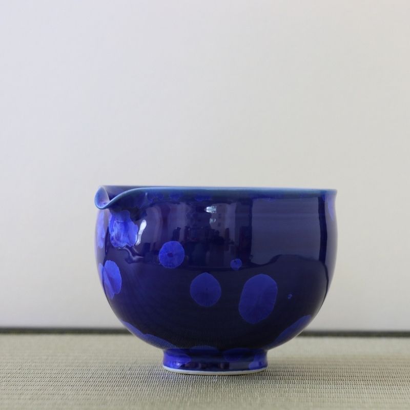 Side view of the Tōan Hana-Kesshō katakuchi bowl showing its rounded form, pouring spout, and deep lapis blue crystalline glaze