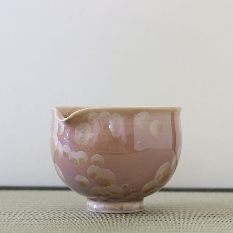 Side view of the Tōan Hana-Kesshō mocha katakuchi bowl showing its rounded form, pouring spout, and cream flower crystal glaze patterns