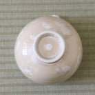 Underside view of the Tōan Hana-Kesshō natural beige katakuchi bowl showing its circular ceramic foot and flower crystal glaze across the base