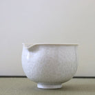 Side view of the Tōan Hana-Kesshō white katakuchi bowl showing its rounded form, pouring spout, and intricate flower crystal glaze
