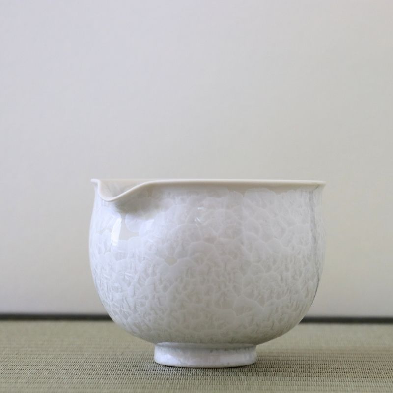 Side view of the Tōan Hana-Kesshō white katakuchi bowl showing its rounded form, pouring spout, and intricate flower crystal glaze