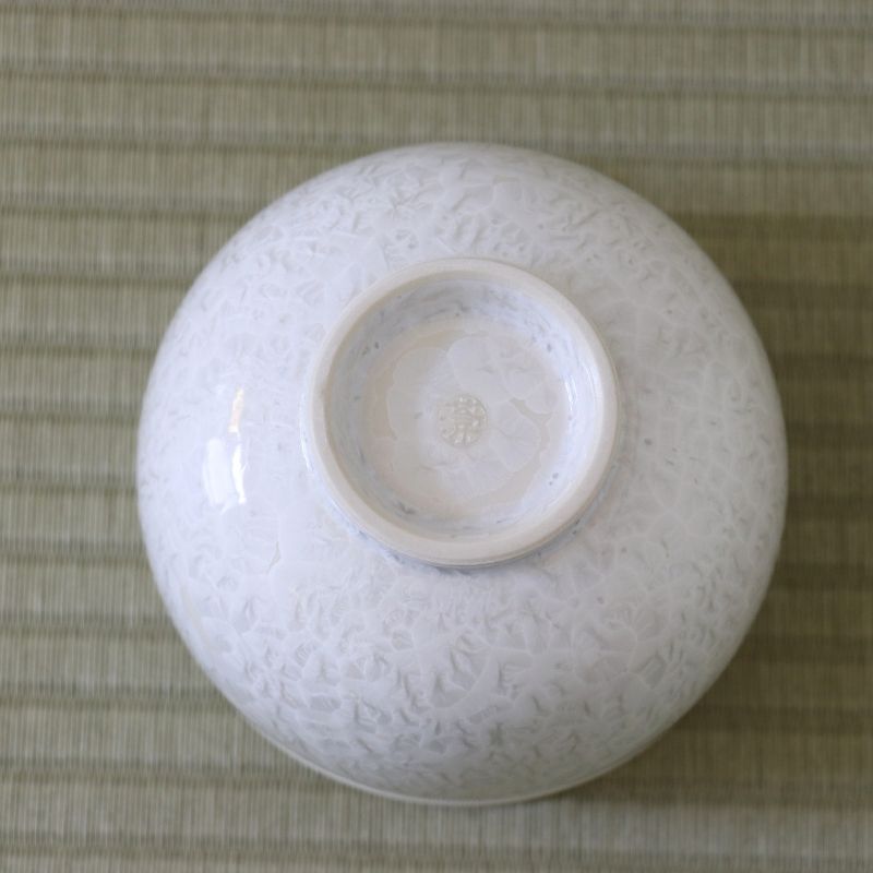 Underside view of the Tōan Hana-Kesshō white katakuchi bowl showing its circular ceramic foot and flower crystal glaze across the base