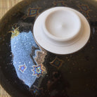 Bottom view of the Touan Hoshi-Kessho matcha bowl showing its circular white ceramic foot surrounded by the dark crystalline glaze