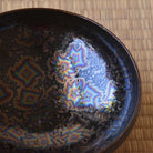 Close-up of the Touan Star Crystal matcha bowl interior showing angular iridescent Hoshi-Kessho crystalline patterns against the deep black glaze