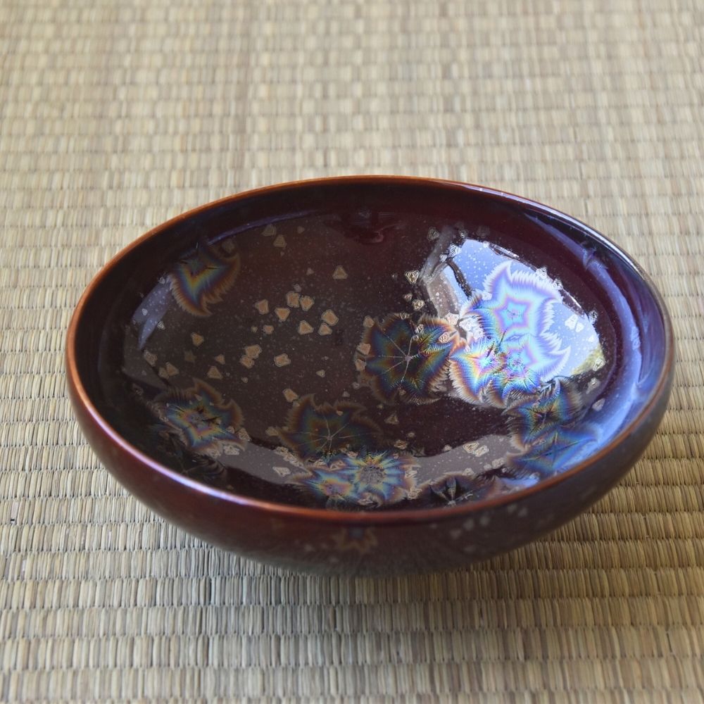Top interior view of the Touan Hoshi-Kessho wine red matcha bowl showing radiant star-like crystal patterns across the glossy interior glaze