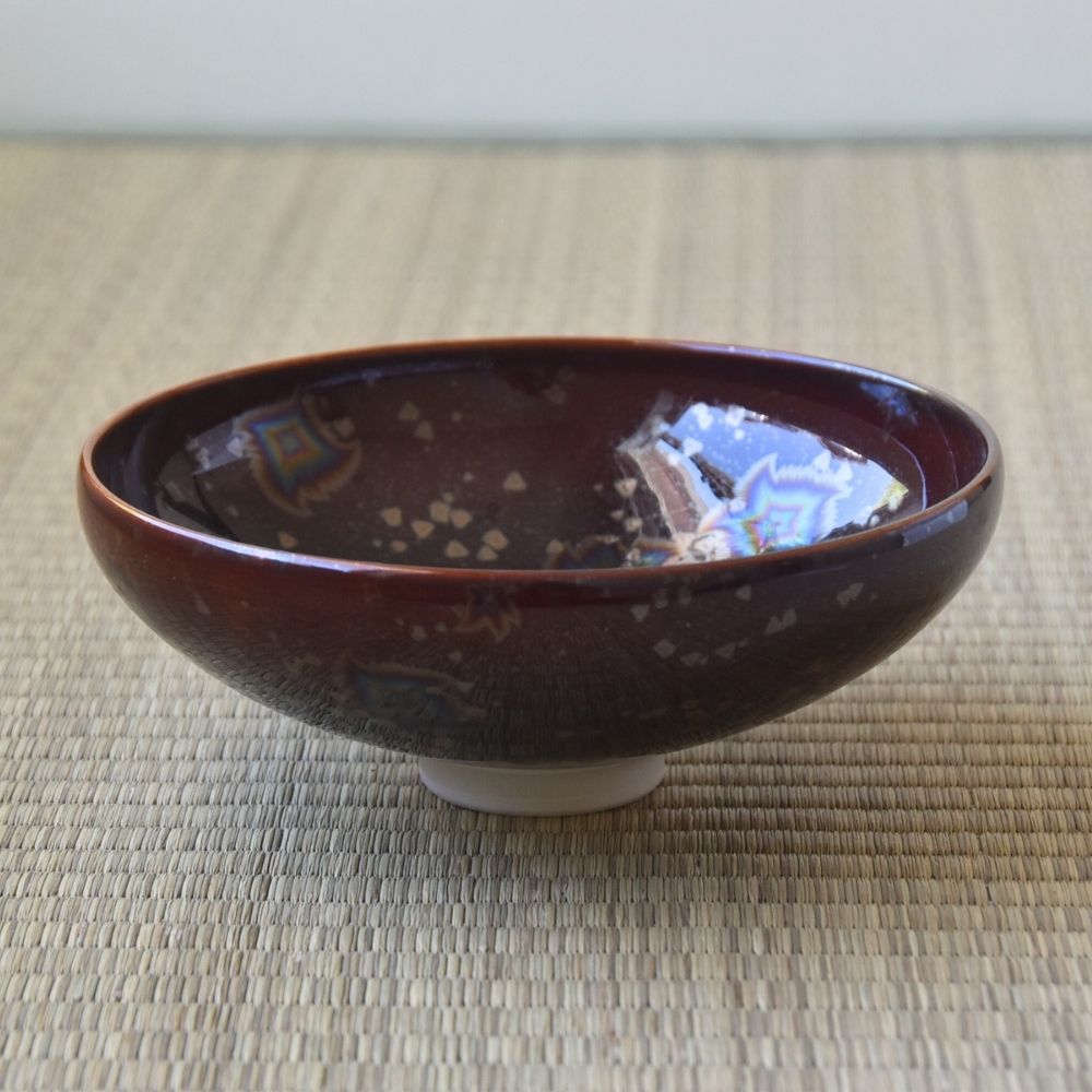 Touan flat matcha bowl featuring a wine red Hoshi-Kessho Star Crystal glaze with intricate iridescent star-like crystalline patterns