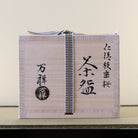 Traditional wooden kiribako presentation box for the weeping sakura Kyo Ware matcha bowl, shown with its paper wrapping and label.
