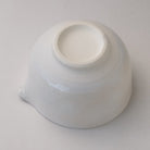 Underside view of the white Mino Ware katakuchi matcha bowl showing its raised ceramic foot and pale glazed exterior