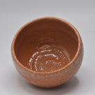 Top view of the Yoshimura Raku-nyu matcha bowl showing its glossy reddish-brown interior and softly irregular rim.