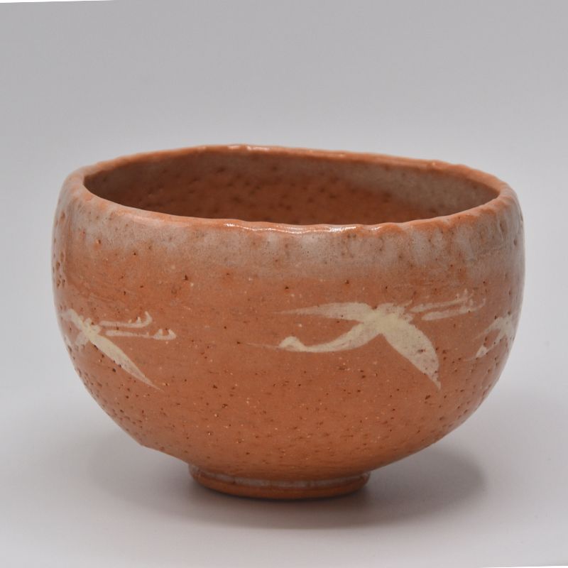 Angled side view of the Flying Cranes matcha bowl showing white crane motifs, its rounded profile, and raised foot.